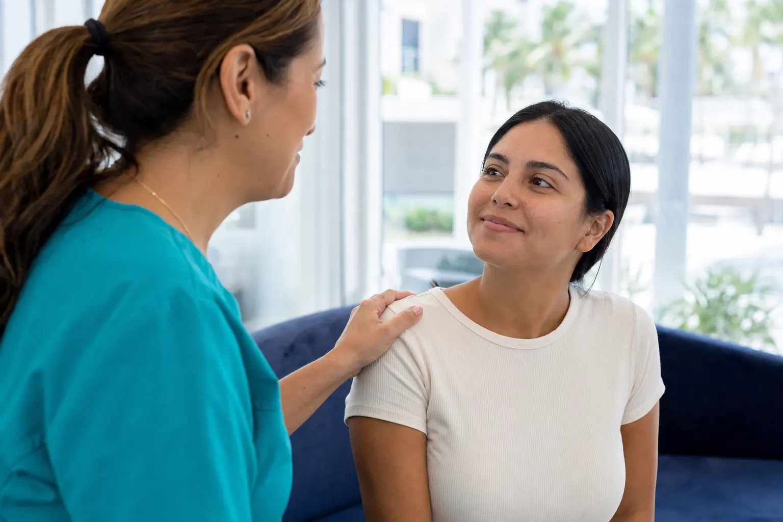 A nurse reassuring a patient with a hand on their shoulder